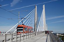 A view of the Tilikum Crossing bridge from the pedestrian and bicycle lane with a streetcar passing by