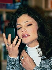 Fran Drescher applying make-up while looking in a compact mirror