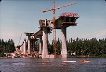 View of several high columns emerging from the water with a crane between them