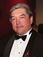 A colour photo of Graham Greene at the Gemini Awards wearing a black and white tuxedo.