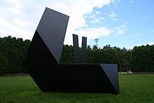 A geometric iron sculpture in a park outdoors