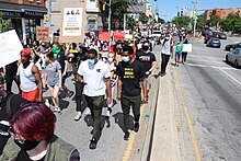 Protesters wearing COVID masks marching down a Baltimore street on May 30