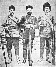 Three stanidn men with rifles