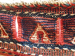 Detail of decorative border, with slits for rope to close and secure bag