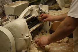 Inserting dough, machine rolls rohlík automatically