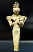 Lizard-headed nude woman nursing a child, Ur, Ubaid 4 period, 4500-4000 BCE, Iraq Museum. "The elongated head, similar to the figures found at Eridu, could represent an elaborate headdress or possibly cranial binding".[38]