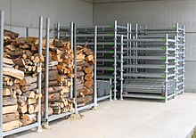 Metal pallets with removable beams, several of which are filled with firewood