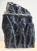 Prisoners escorted by a soldier, on a victory stele of Sargon of Akkad, circa 2300 BCE.[23] The hairstyle of the prisoners (curly hair on top and short hair on the sides) is characteristic of Sumerians, as also seen on the Standard of Ur.[24] Louvre Museum.