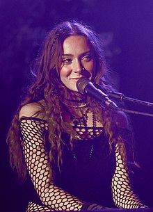 Foto einer Frau, die in ein Mikrofon singt