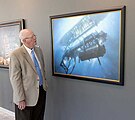 Sherman Wetmore, lead engineer on the Glomar Explorer, looking at an oil painting of the ship raising the Soviet submarine.
