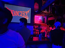 Photograph of a busy bar under red lighting