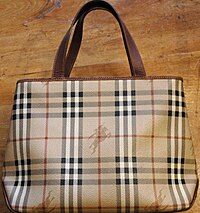 A purse in the tan, black, and white Burberry check pattern, with rearing-horseman logos superimposed