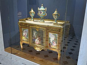 Commode of Madame du Barry; by Martin Carlin (attribution); 1772; oak base veneered with pearwood, rosewood and amaranth, soft-paste Sèvres porcelain, bronze gilt, white marble; 87 x 119 cm; Louvre[64]