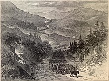 Sepia toned print shows soldiers marching through mountainous country.