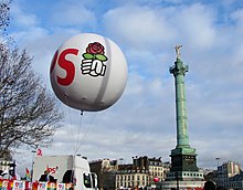 A balloon with the letters "PS" and a schematic right fist holding a rose. In the background, the Vendôme Column of Paris.