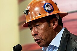 Pedro Montes wearing a hard hat adorned with a sticker of Evo Morales.