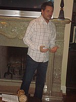 Country music singer Ty Herndon standing before a fireplace.