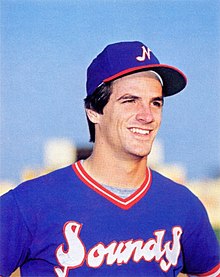A man in a blue baseball jersey with "Sounds" on the front and blue cap with a big smile