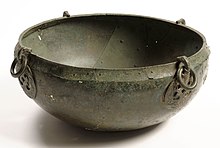 A hanging bowl seen from the side and slightly above, with two hook escutcheons visible on the outside of the rim