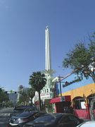 Side view of the Alex Theatre and the 100-foot-tall (30 m) art-deco column with neon lights, topped by a spiked, neon sphere that gave it a "starburst" appearance (2014).