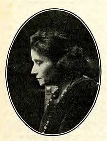 Profile of a short-haired woman in a dark suit