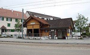 Wooden building with gabled roof next to street-level platform