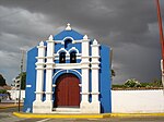 A church with a blue facade with white columns
