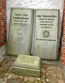 Photograph of three stone gravestones; two standing (that of Charles to the left), and one (of Ludwig) square on the floor in front of them. The right-hand gravestone is of John Augustus Ross, born 1852, died 1859.