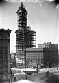 The Smith Tower, designed by Gaggin & Gaggin of Syracuse, New York; completed 1914, shown here under construction in 1913. At 38 stories, it was tallest office building west of the Mississippi River until the Kansas City Power & Light Building (1931), and the tallest building on the West Coast until the Space Needle (1962).[142]