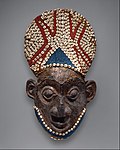 Royal mask; by artists of the Bamum people (Cameroon); before 1880; wood, copper, glass beads, raffia and shells; height: 66 cm; Metropolitan Museum of Art[99]
