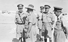 a black and white photograph of officers conversing in a desert setting