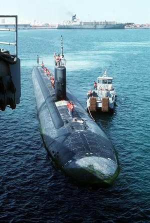 USS Topeka (SSN-754) prepares to dock with the assistance of a tugboat.