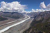 Aerial photo of a long river coming from a distant glacier among the rocky mountains