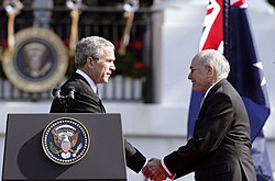 Photograph of Bush shaking hands with Australian Prime Minister John Howard, during the State Arrival Ceremony held for the Prime Minister on the South Lawn of the White House, May 2006