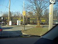The Coke Express rolls through a level crossing. Cars display both the CSX logo and the words COKE EXPRESS