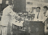 Ong Keng Seng, Executive Director of the school, lays the school flag on David Chen's casket.