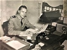 Naval officer in uniform sitting behind a desk and working