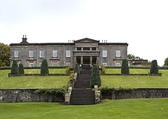 A photograph of the north face of Aberlour House, with a flight of stone steps leading to the house in the foreground