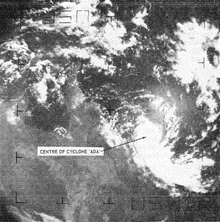 Satellite image of a small tropical cyclone near the northeastern coast of Australia. A long band of clouds is seen extending to the southeast.