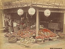 A hand-colored silver albumen print of a fruit market in Japan taken by Kusakabe Kimbei