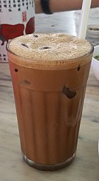 A glass of Iced Ipoh White Coffee with straw