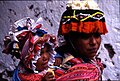 Quechua woman in Pisac, Peru, carrying a child in an aguayo