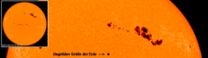 Sonnenflecken im Vergleich zur Größe der Erde. Die größte Fleckengruppe rechts gehört zum Typ F.