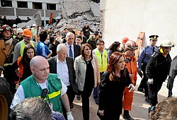 Woman walking through a disaster area with many other people
