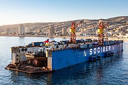 SOCIBER floating drydock, Valparaiso III with tugboat Pequen, being worked on in the cradle, in Valparaiso, Chile