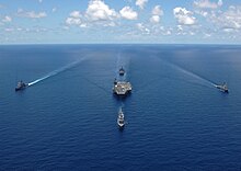 Four warships sailing alongside George Washington
