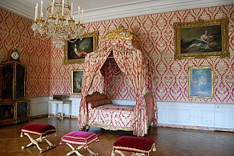 1755 Lit à la polonaise by Nicolas Heurtaut,[25] with folding stools arranged before it, Bedchamber of the Dauphine at the Palace of Versailles. Note square frame under crown is covered with the same fabric.