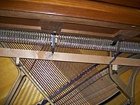 Detail of the interior structure of the Gulbransen spinet shown above. The drop action, lying below the level of the keyboard, can be seen, as well as the extreme angling of the strings needed to provide sufficient length of strings within the limited case height. Click on image for expanded view.