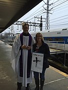 A priest has an "Ashes to Go" station for commuters at a train station