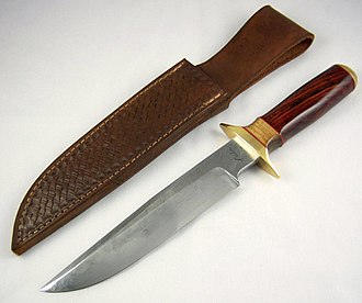 Large knife with polished wooden handle, close to a leather sheath